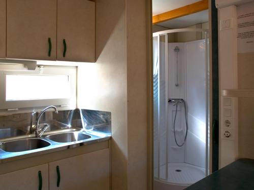 a small kitchen with a sink and a shower at Camping Cobijo in Vinuesa