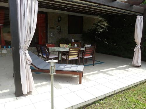 a patio with a table and chairs and curtains at Paomà trentova in Agropoli