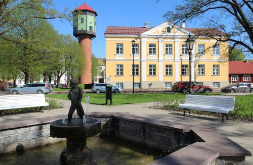 a statue of a person in a fountain in front of a building at Lossikambri külaliskorterid in Viljandi