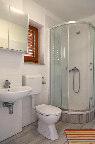 a bathroom with a toilet and a sink and a shower at Apartments Laura in Pinezici
