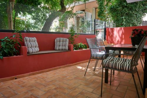 a patio with chairs and a table and a bench at Marble House in Athens
