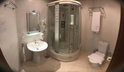a bathroom with a shower and a sink and a toilet at Ataer Hotel in Antalya