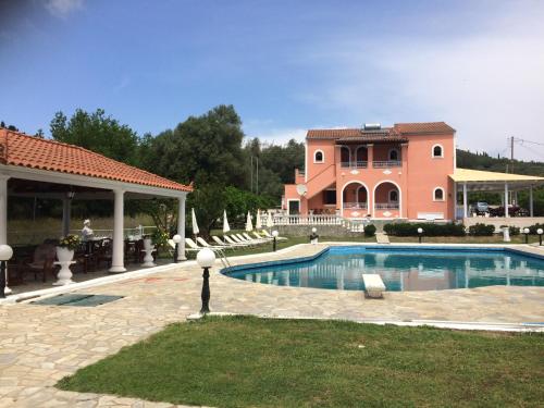 a house with a swimming pool in front of a house at Regina Nina in Vasilátika