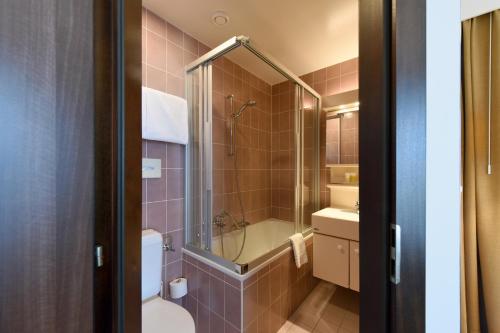 uma casa de banho com um chuveiro, um WC e um lavatório. em Elite em Lausana