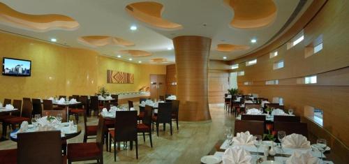 a dining room with tables and chairs in a restaurant at Hotel Sewa Grand Faridabad in Faridabad