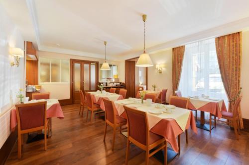 ein Restaurant mit Tischen und Stühlen in einem Zimmer in der Unterkunft Elite in Lausanne