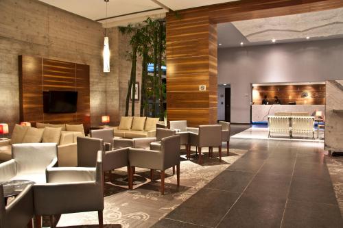 a lobby of a hotel with chairs and tables at Casa Inn Premium Hotel Queretaro in Querétaro