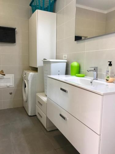 a white kitchen with a sink and a washing machine at Apartamentos Rocas del Mar in Costa Del Silencio