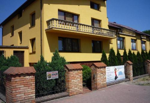 una casa gialla con una recinzione davanti di VillaMaria a Danzica
