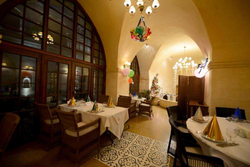 ein Restaurant mit Tischen, Stühlen und einem Kronleuchter in der Unterkunft Shmayaa Hotel in Midyat