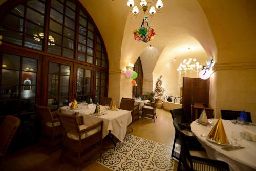 a restaurant with tables and chairs and a chandelier at Shmayaa Hotel in Midyat