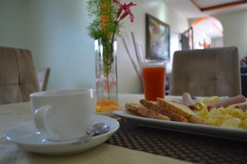 a table with a plate of food and a cup of coffee at Hotel Renacer in Santo Domingo