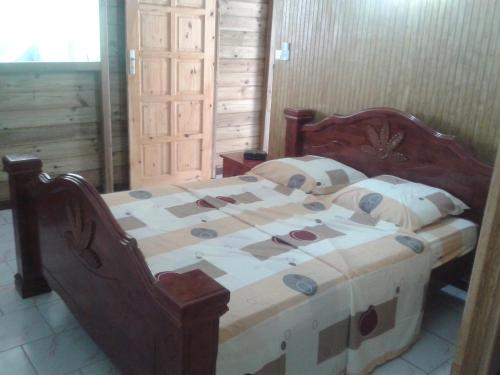 a wooden bed in a room with at La Belle Creole in Morne-à-lʼEau