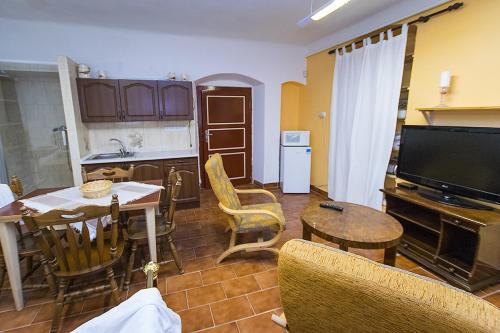 een woonkamer met een keuken en een tafel met stoelen bij Penzion Klášter in Třebenice