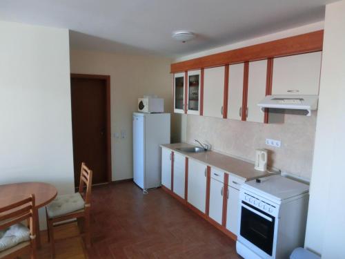 a kitchen with a white refrigerator and a table at Sea View apartment, Panorama, Pools and beach, Sveti Vlas in Sveti Vlas