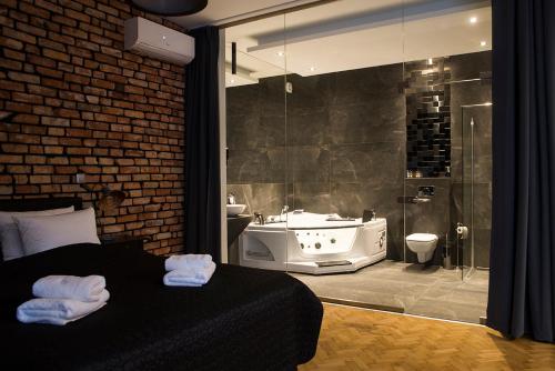 a bedroom with a bathroom with a tub and a sink at Leo Apartments Old Town in Krakow