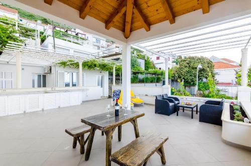 eine Terrasse mit einem Holztisch und Bänken darauf in der Unterkunft Miracle Apartments in Dubrovnik