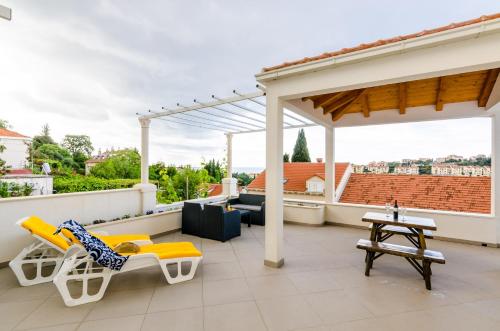 eine Terrasse mit Stühlen und Tischen auf dem Dach in der Unterkunft Miracle Apartments in Dubrovnik