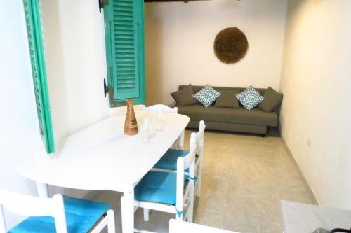 アルゲーロにあるPalauet cosy old town apartments in Alghero IUN Q6390のダイニングルーム(テーブル、ソファ付)