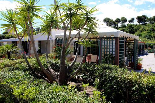 Un edificio con dos palmeras delante. en Hotel Parco Carabella, en Vieste