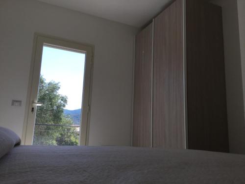 a bedroom with a bed and a large window at B&B Somiar in San Teodoro
