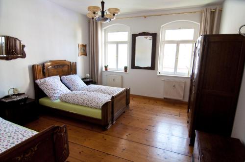 a bedroom with a bed and a couch and two windows at Kunsthofperle in Dresden