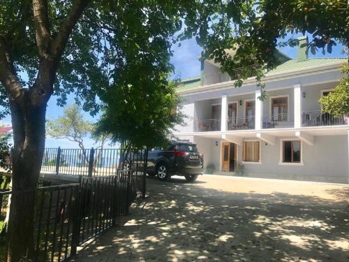 a car parked in front of a white building at 15 Kviparosi Guest House in Makhinjauri