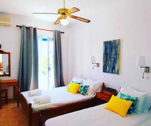 a bedroom with two beds and a ceiling fan at Villa Dioni in Kamari