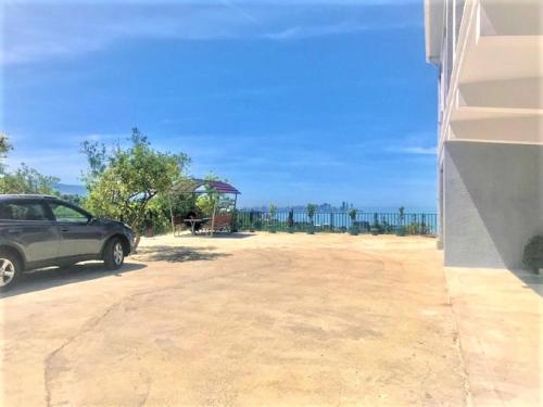a car parked in a parking lot with the ocean in the background at 15 Kviparosi Guest House in Makhinjauri