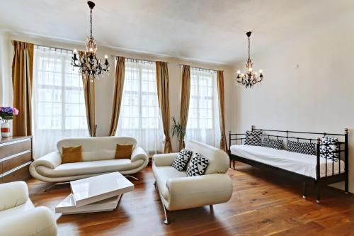 a living room with a bed and a couch and chairs at Historic Centre Apartments II in Prague