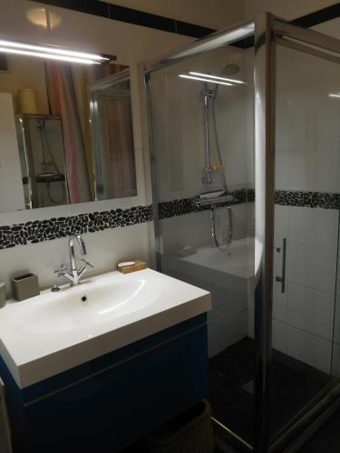 une salle de bain avec un lavabo et une douche dans l'établissement Appart - vue mer Menton Cap Martin, à Roquebrune-Cap-Martin