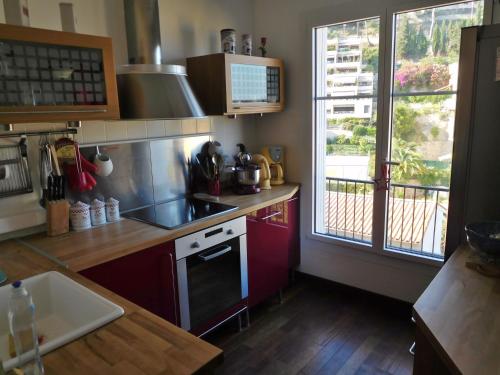 une cuisine avec un évier et une cuisinière four supérieur dans l'établissement Appart - vue mer Menton Cap Martin, à Roquebrune-Cap-Martin