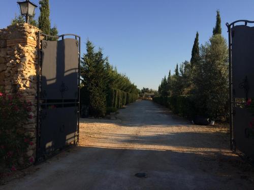 an entrance to a driveway with a gate and trees at Casa Go'El in Chiaramonte Gulfi