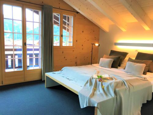 a bedroom with a bed and a large window at Chalet ELK Lenk in Lenk