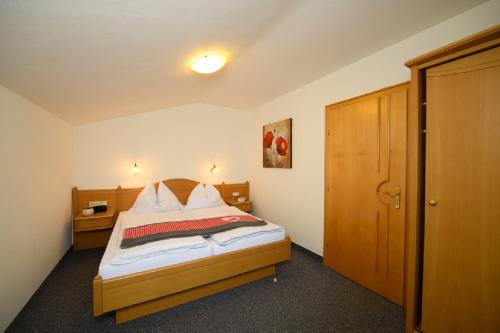 Schlafzimmer mit einem Bett mit einem Kopfteil aus Holz in der Unterkunft Wallnerhof in Großarl