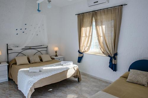 Un dormitorio con dos camas y una ventana. en Villa Saline, en Palinuro