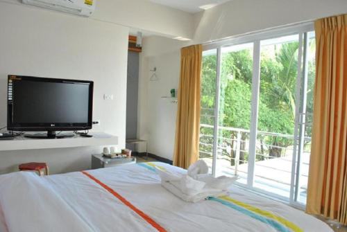 a bedroom with a bed with a flat screen tv at O.U.M. Hotel - โรงแรมโอยูเอ็ม in Uttaradit