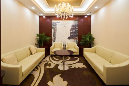 a waiting room with couches and a table and a chandelier at Soluxe Hotel Niamey in Niamey