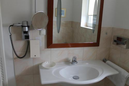 a bathroom with a sink and a mirror at Vier Jahreszeiten Bensersiel in Bensersiel