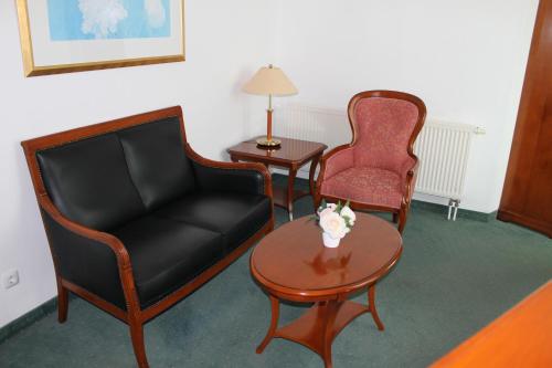 a room with a couch and two chairs and a table at Vier Jahreszeiten Bensersiel in Bensersiel