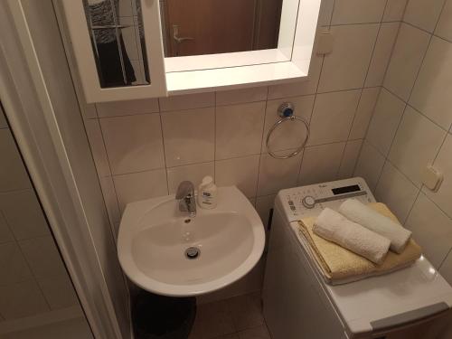 a small bathroom with a sink and a mirror at Apartments and Rooms Dobrila in Jelsa