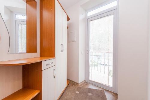 a kitchen with a window and a white cabinet at Prie Ąžuolo in Juodkrantė