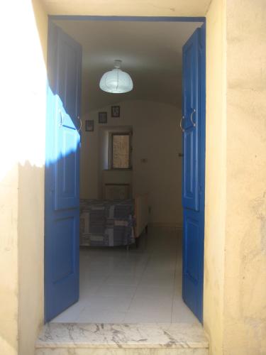 Una puerta azul abierta a una habitación con cama en Casetta Blu, en Tricarico