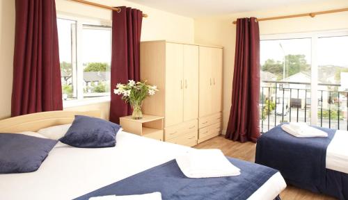 1 dormitorio con 2 camas y ventana grande en Menlo Park Apartments, en Galway