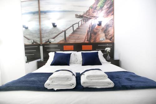 1 dormitorio con 1 cama con una pintura en la pared en Hostal La Bañezana, en Madrid