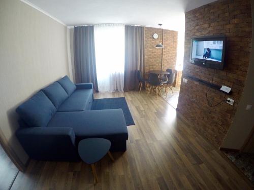 a living room with a blue couch and a tv at Apartment near Megacenter in Chernihiv