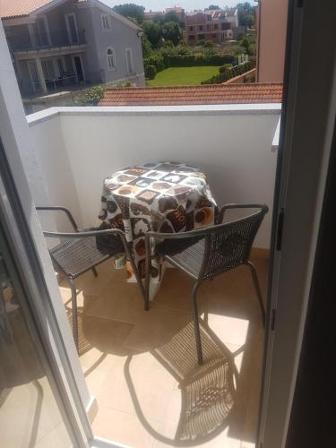 a table and two chairs on a balcony at Apartments Zova in Medulin