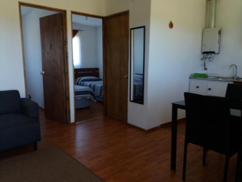 una sala de estar con una puerta que da a un dormitorio en Cabañas M y M Frutillar, en Frutillar