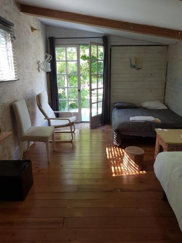 a room with a bedroom with a bed and a chair at Maison d'Hôtes Le Calme in Saint-Tropez