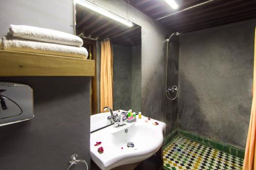 a bathroom with a white sink and a mirror at Riad Fez Yamanda in Fès
